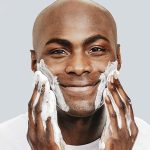 Black man is washing his face